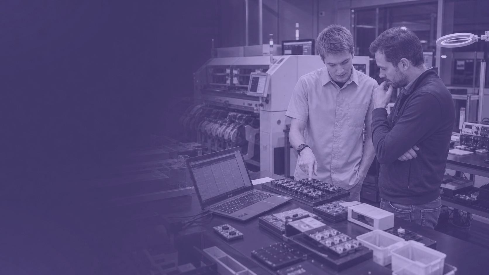 Un ingénieur NEYOS explique une étape de production IoT à un client dans l'atelier.